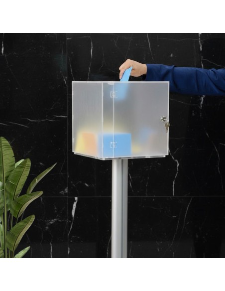 mano intenta a inserire foglio azzurro dentro a una urna in plexiglass da terra
